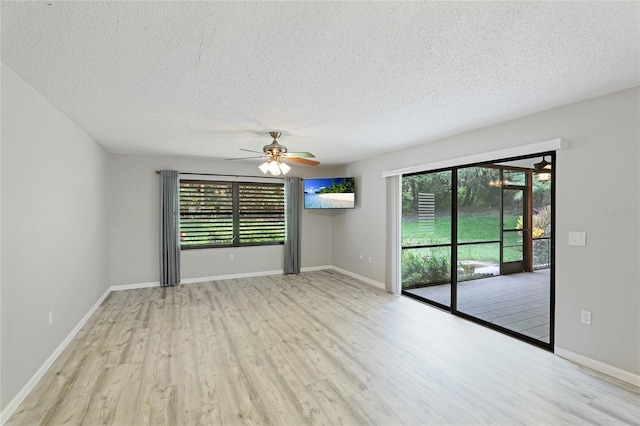 empty room featuring ceiling fan, a textured ceiling, and light wood-type flooring