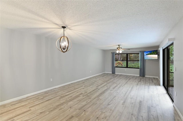 empty room featuring ceiling fan with notable chandelier, a textured ceiling, and light wood-type flooring