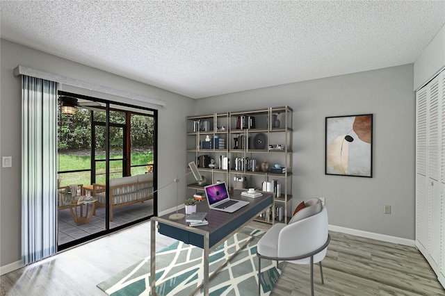 home office featuring wood-type flooring and a textured ceiling