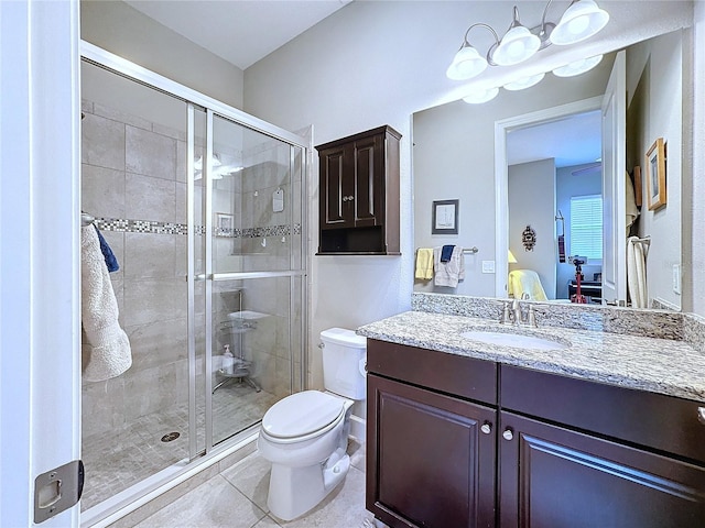 full bathroom featuring a stall shower, vanity, toilet, and tile patterned floors