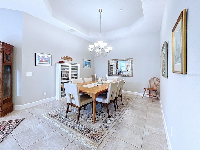 dining room featuring light tile patterned floors, baseboards, visible vents, a raised ceiling, and a chandelier