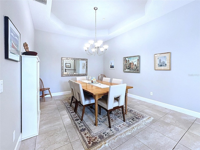 dining area featuring light tile patterned floors, baseboards, a tray ceiling, and a notable chandelier