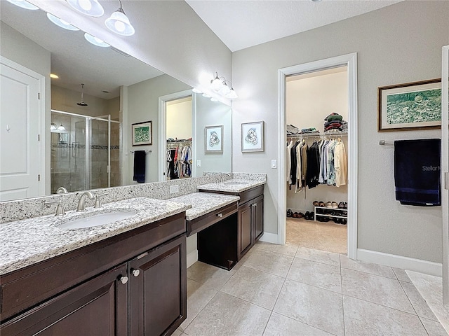 bathroom with baseboards, a stall shower, vanity, and tile patterned floors