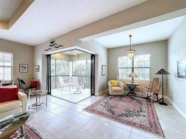 interior space featuring light tile patterned floors, a textured ceiling, baseboards, and a healthy amount of sunlight