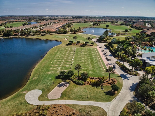 drone / aerial view with a water view and view of golf course