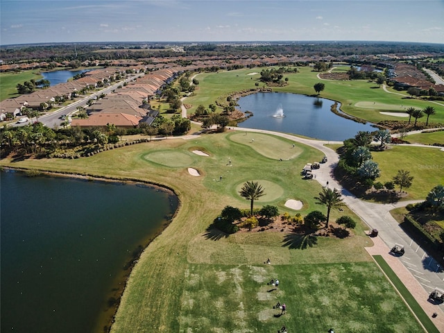 drone / aerial view featuring view of golf course and a water view