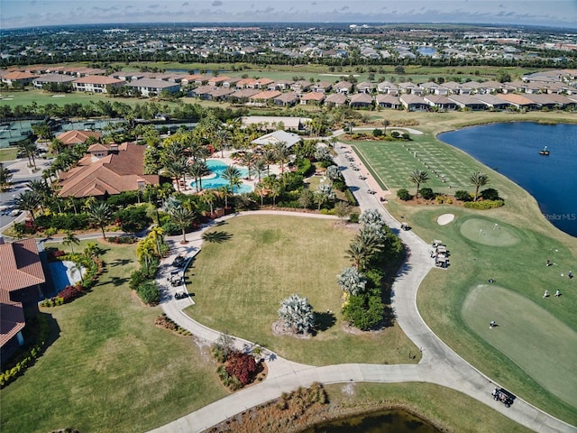 drone / aerial view featuring golf course view, a water view, and a residential view