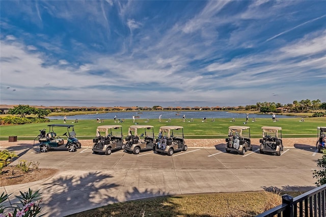 surrounding community featuring a water view, uncovered parking, and a yard