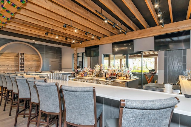 bar featuring a community bar, track lighting, and wood finished floors