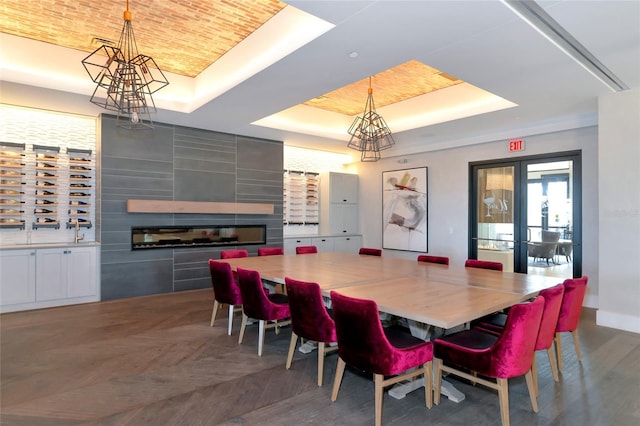 dining area with a tray ceiling, parquet floors, a fireplace, brick ceiling, and baseboards