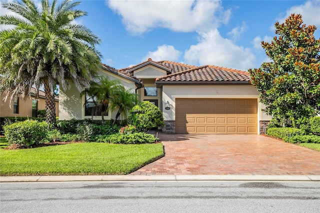 mediterranean / spanish home featuring a front yard and a garage