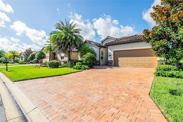 mediterranean / spanish home with a front yard and a garage