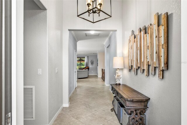 corridor with a notable chandelier and crown molding