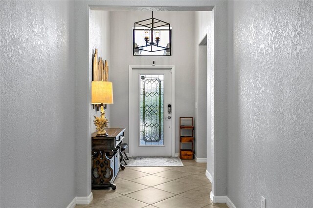 foyer with an inviting chandelier and light tile patterned flooring