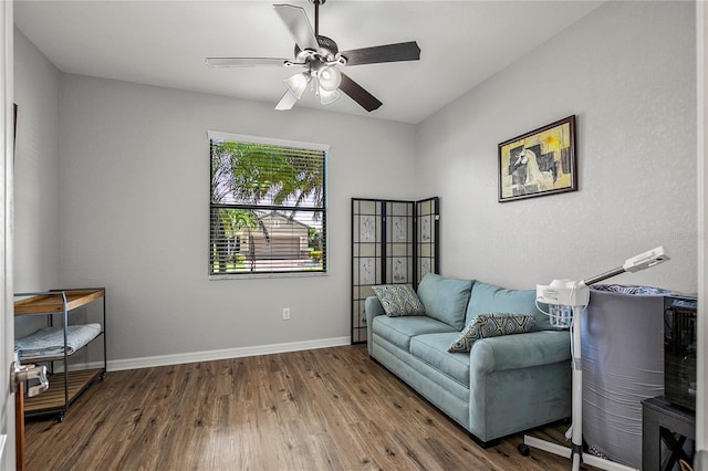 living room featuring ceiling fan and dark wood-type flooring