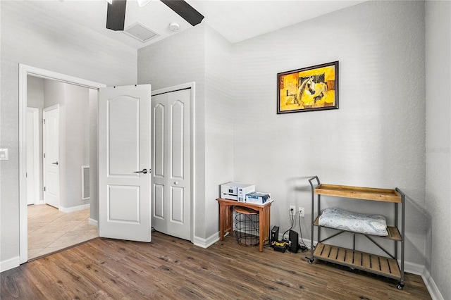 bedroom with ceiling fan, wood-type flooring, and a closet