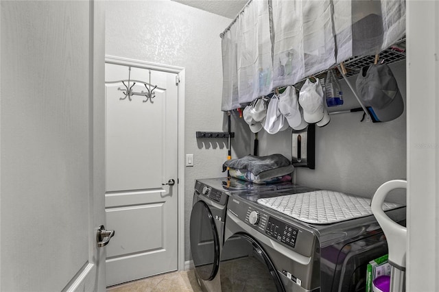 washroom with washer and dryer, a notable chandelier, and light tile patterned flooring