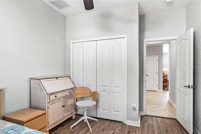 bedroom with ceiling fan, light wood-type flooring, and a closet