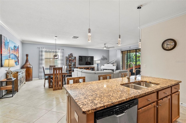 kitchen with stainless steel dishwasher, ceiling fan, sink, decorative light fixtures, and a center island with sink