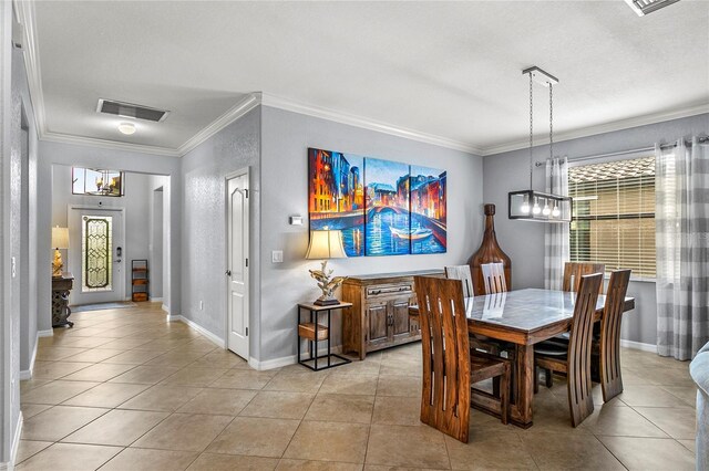 dining room with a textured ceiling, a notable chandelier, light tile patterned floors, and ornamental molding