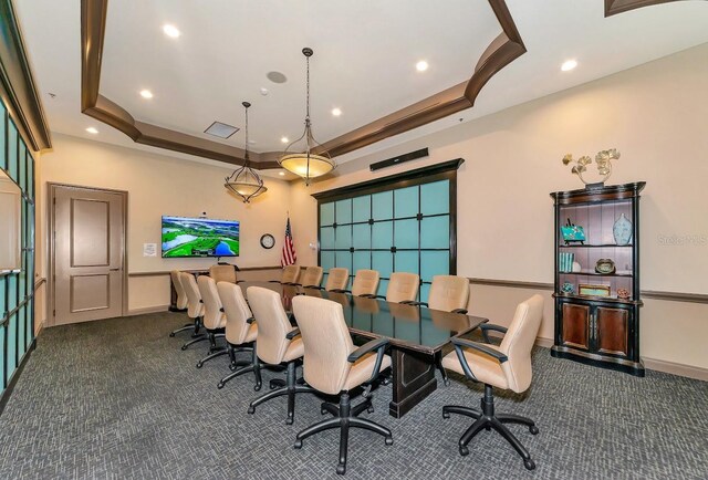 carpeted dining room featuring a raised ceiling