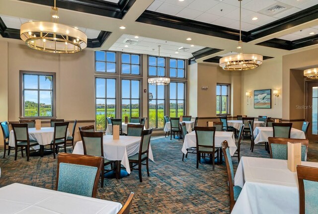 carpeted dining space featuring beamed ceiling, a towering ceiling, coffered ceiling, and a notable chandelier