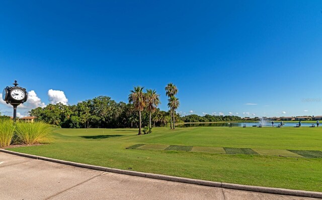 view of property's community featuring a lawn and a water view