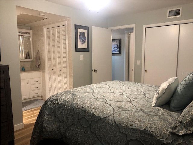 bedroom featuring two closets and wood-type flooring