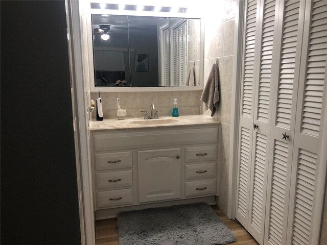 bathroom with hardwood / wood-style flooring, tasteful backsplash, and vanity