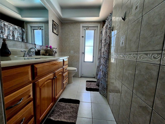 bathroom featuring toilet, tile patterned floors, curtained shower, vanity, and tile walls