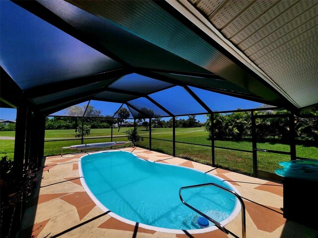 view of swimming pool with a lanai, a yard, and a patio