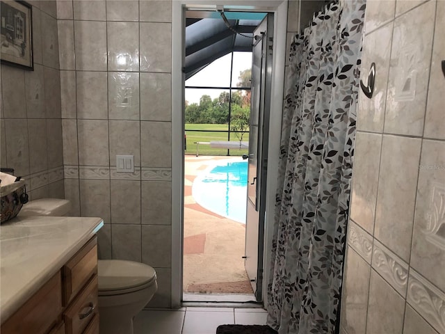 bathroom featuring a shower with curtain, tile walls, and toilet