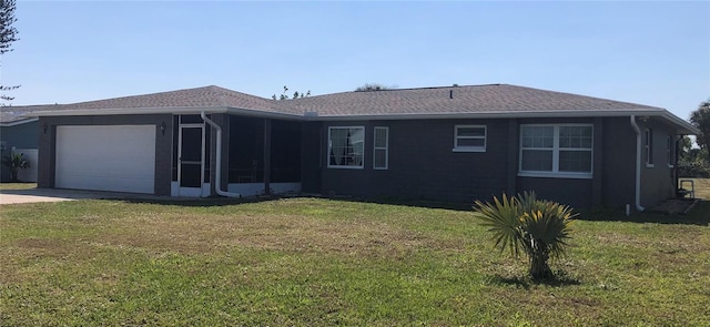 view of front of property with an attached garage, a sunroom, a front lawn, and concrete driveway