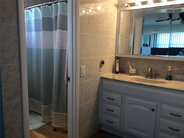 full bath featuring a ceiling fan, backsplash, tile walls, and vanity