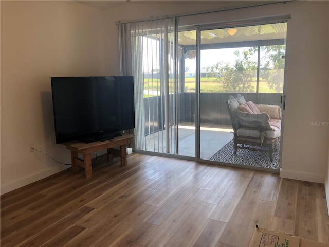 living area with baseboards and wood finished floors