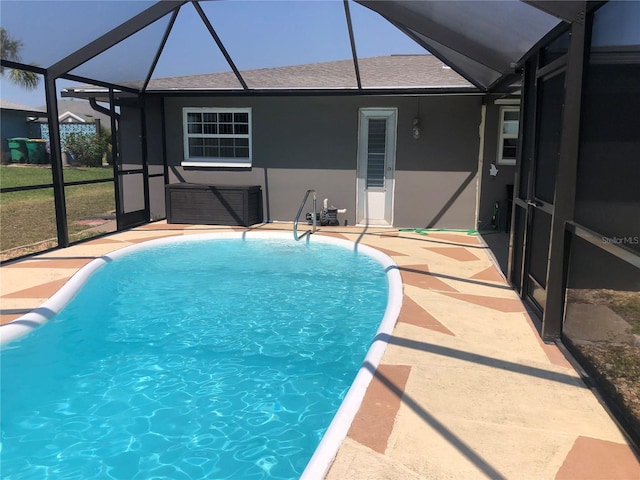 pool with glass enclosure and a patio area