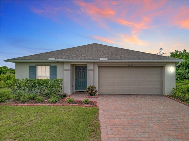 single story home featuring a garage and a yard