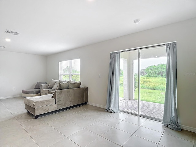 living room featuring light tile patterned floors, baseboards, and visible vents