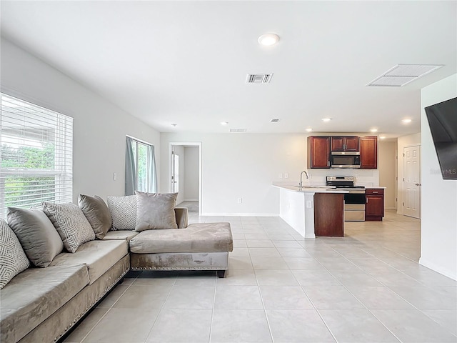 living area featuring light tile patterned floors, baseboards, visible vents, and recessed lighting