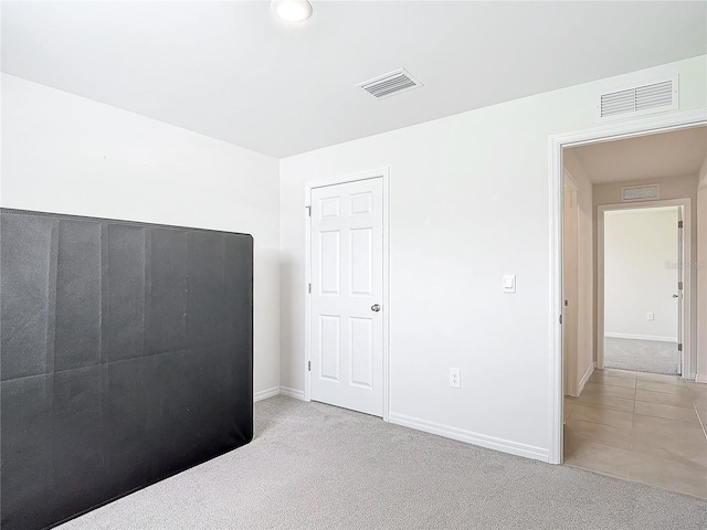 unfurnished bedroom featuring light carpet and visible vents