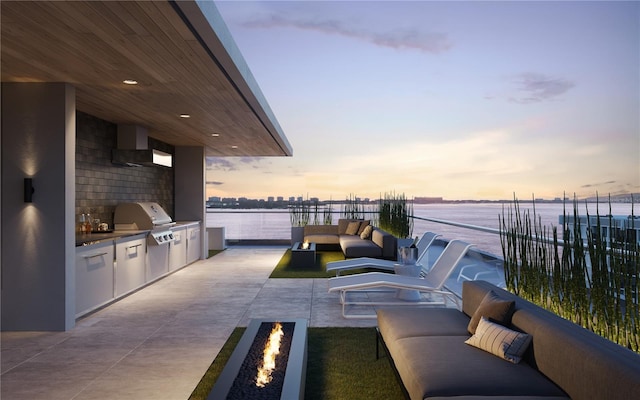 patio terrace at dusk featuring area for grilling, grilling area, an outdoor living space with a fire pit, and a water view