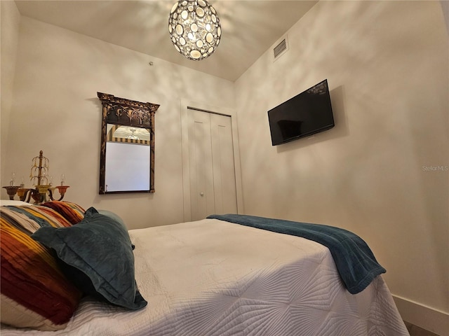 bedroom with a closet and a notable chandelier