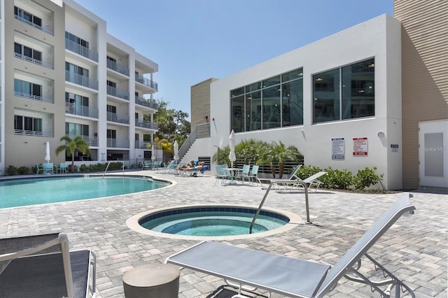 view of swimming pool featuring a community hot tub and a patio