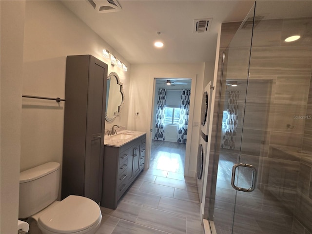 bathroom with tile patterned floors, vanity, a shower with shower door, and toilet