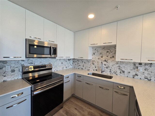 kitchen with sink, white cabinetry, and stainless steel appliances