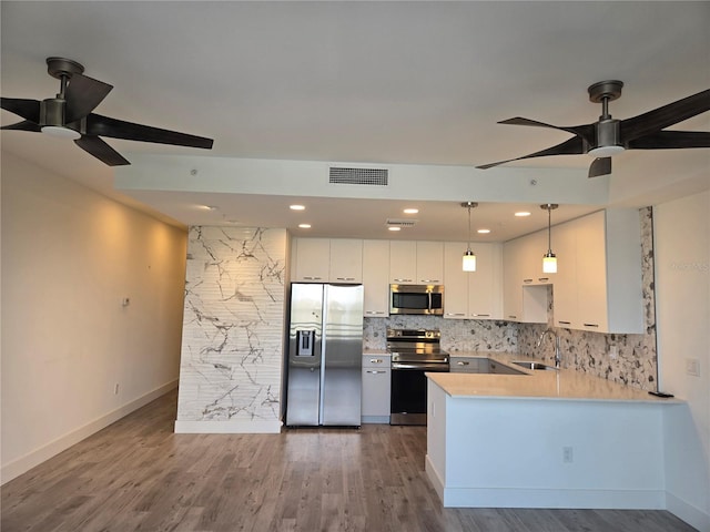 kitchen with pendant lighting, backsplash, ceiling fan, white cabinetry, and stainless steel appliances