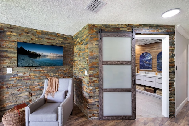 living area with a textured ceiling and wood-type flooring