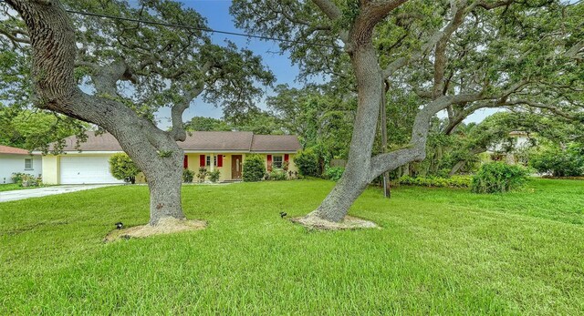 ranch-style home featuring a garage and a front lawn