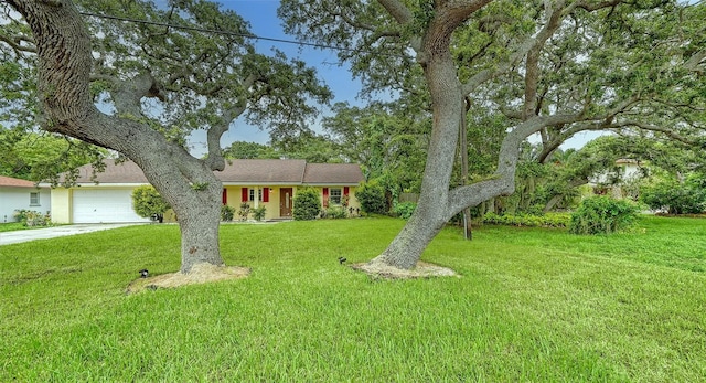 ranch-style house featuring a garage, concrete driveway, and a front lawn