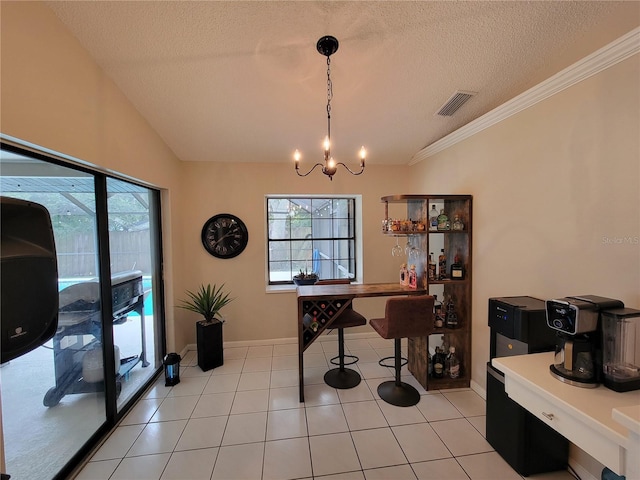 tiled dining area with a textured ceiling, ornamental molding, vaulted ceiling, and a notable chandelier